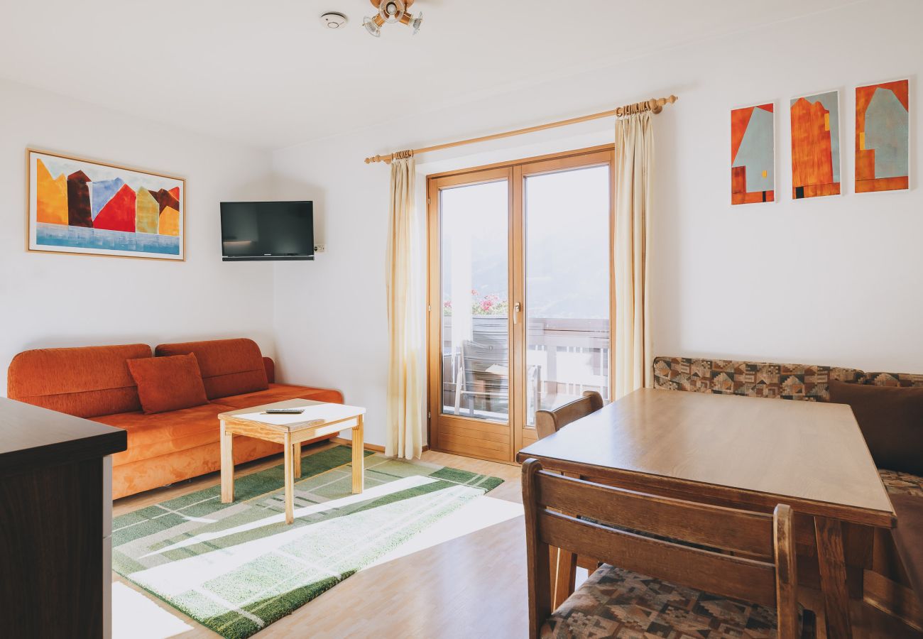 Dining room in the holiday apartment Apartments Haus Altenberger by we rent. Dining table, kitchen, living room, and balcony.